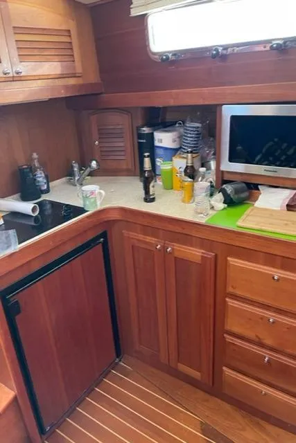 Slide: The Image of 2006 Sabre 38 Hard Top Express galley with wooden cabinetry and modern appliances. - 18