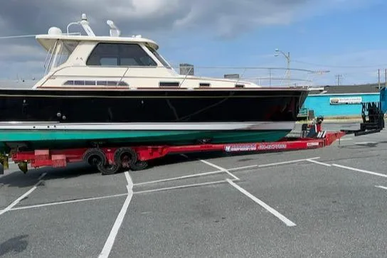 Slide: The Image of 2006 Sabre 38 Hard Top Express boat on a red trailer in a parking lot. - 21