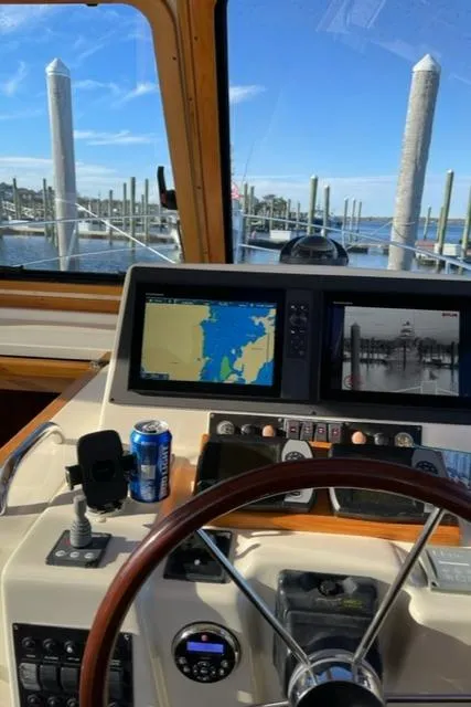 Slide: The Image of 2006 Sabre 38 Hard Top Express helm with navigation screens and marina view. - 9