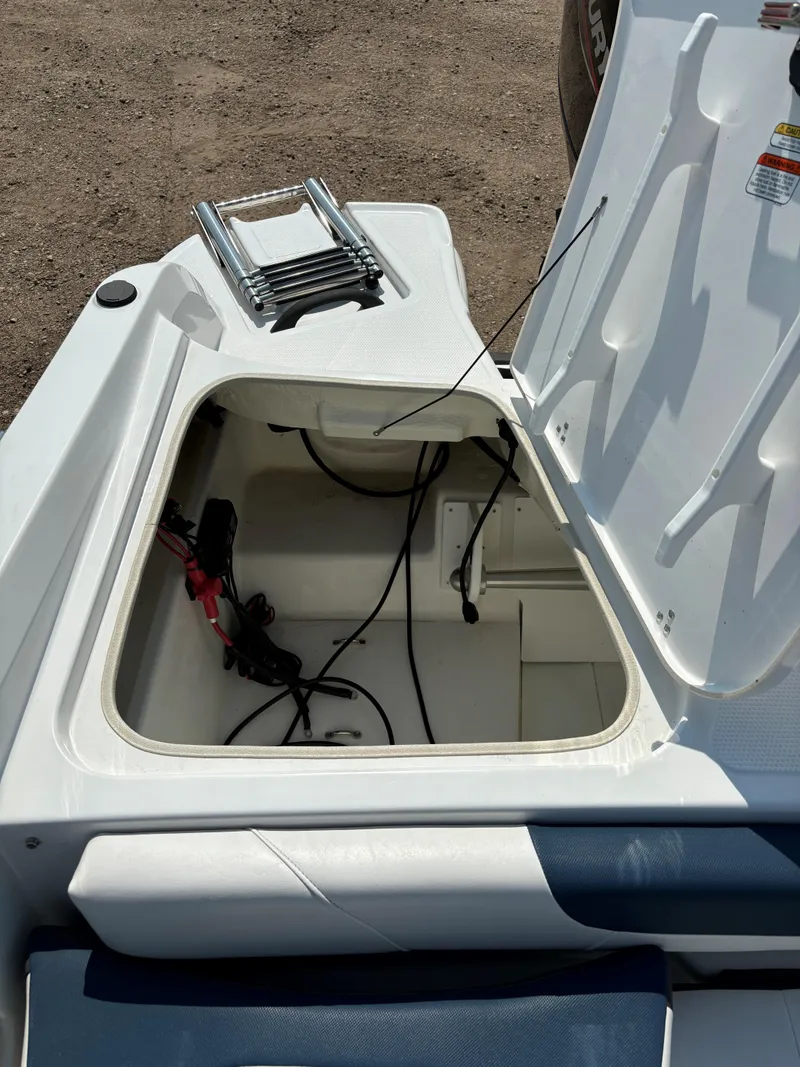 Slide: The Image of Open storage compartment in 2023 Tahoe 185 S boat with visible wiring. - 11