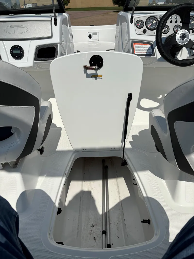 Slide: The Image of 2023 Tahoe 185 S boat interior with open storage compartment and dashboard view. - 18