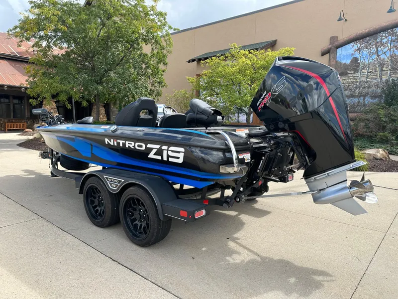 Slide: The Image of 2023 Nitro Z19 Pro boat on trailer, black and blue design, outdoor setting. - 2