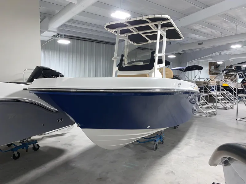 Slide: The Image of 2024 Bayliner Trophy 20 CC boat in showroom, blue and white hull, center console. - 2