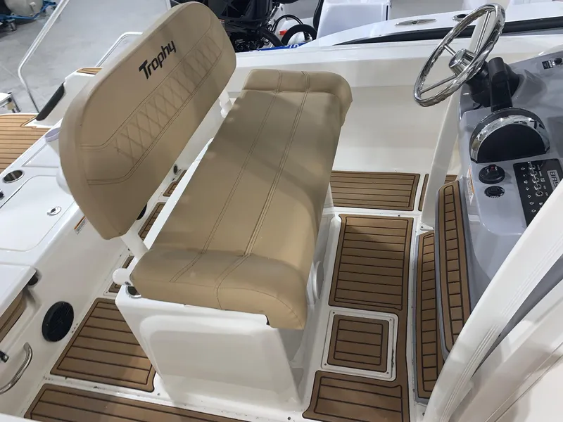 Slide: The Image of 2024 Bayliner Trophy 20 CC boat interior with tan seating and wood flooring. - 11