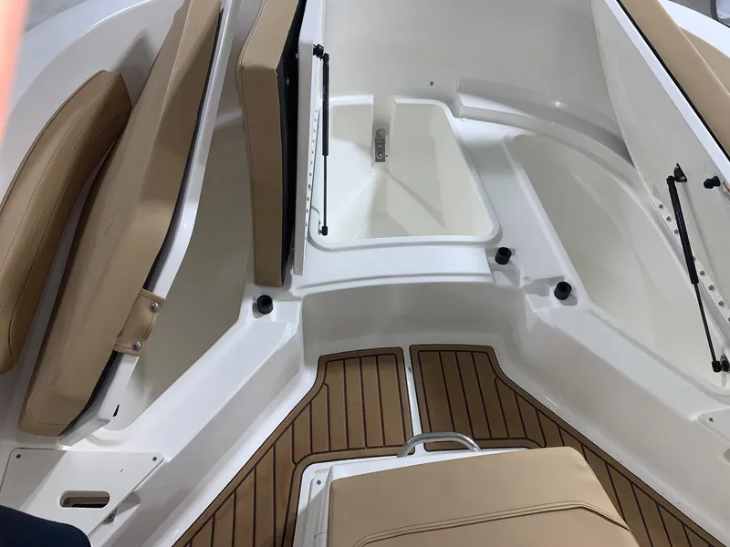 Slide: The Image of 2024 Bayliner Trophy 20 CC boat interior with tan seating and white storage compartments. - 16