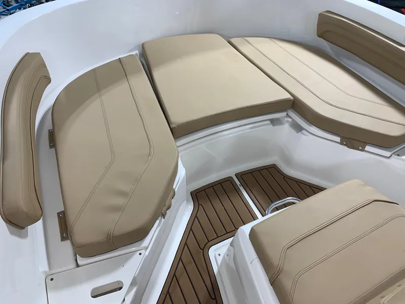Slide: The Image of 2024 Bayliner Trophy 20 CC boat with beige cushioned seating and teak flooring. - 17
