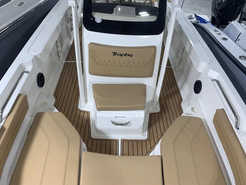 Slide: The Image of 2024 Bayliner Trophy 20 CC boat interior with tan seating and wood flooring. - 18