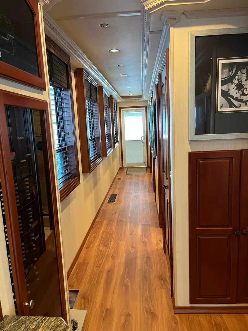 Slide: The Image of 2009 Fantasy Houseboat interior hallway with wooden flooring and cabinets. - 13