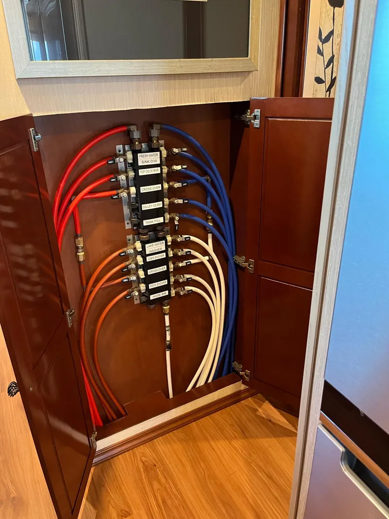Slide: The Image of Houseboat plumbing system with color-coded pipes inside a wooden cabinet, Fantasy model, 2009. - 15
