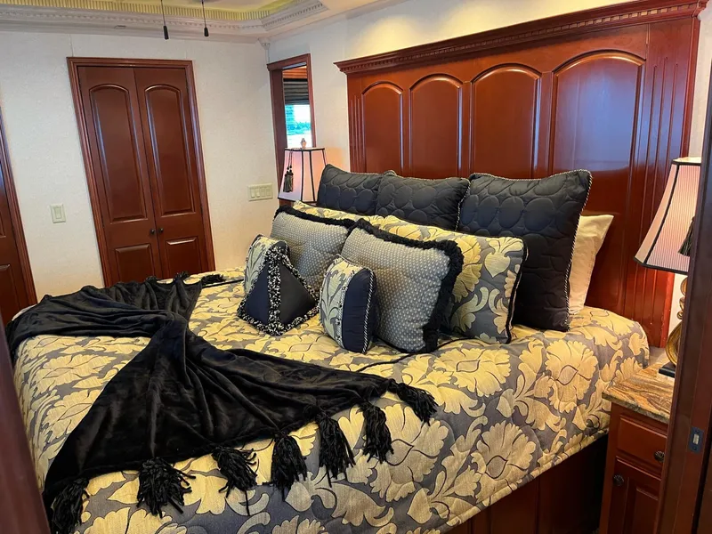 Slide: The Image of Luxurious bedroom in a 2009 Fantasy Houseboat with elegant bedding and wooden decor. - 18