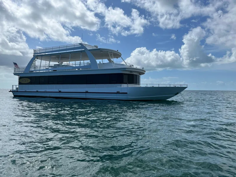 Slide: The Image of 2009 Fantasy Houseboat on open water under a partly cloudy sky. - 2
