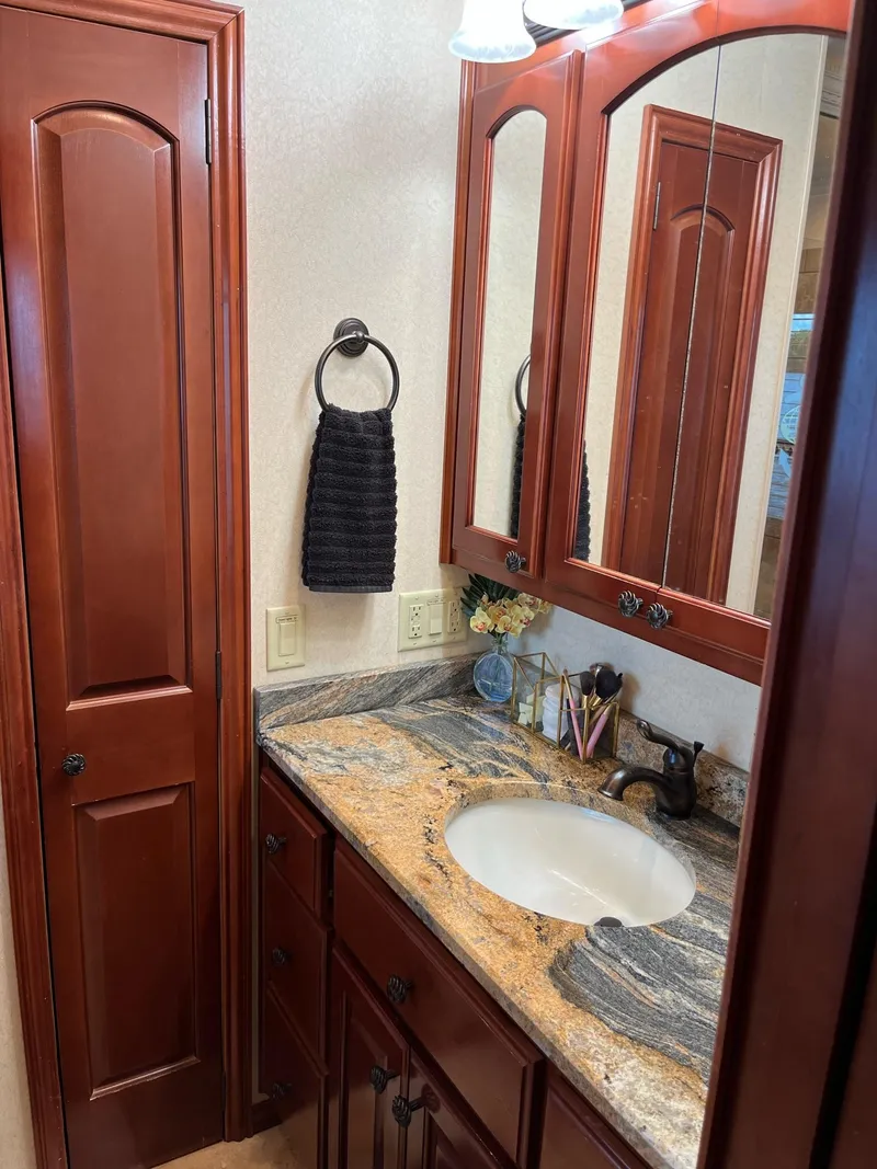 Slide: The Image of Elegant bathroom vanity in a 2009 Fantasy Houseboat with granite countertop and wooden cabinets. - 20