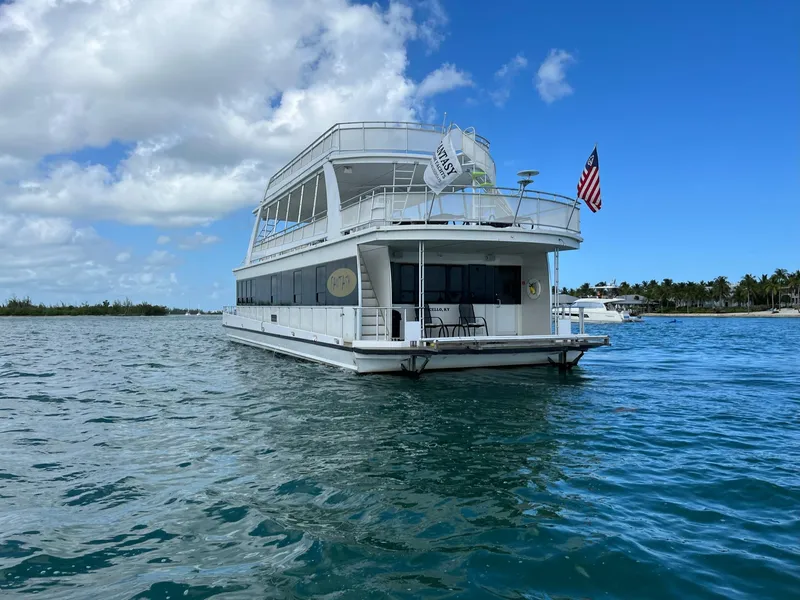 Slide: The Image of White 2009 Fantasy Houseboat on calm blue water under a partly cloudy sky. - 5