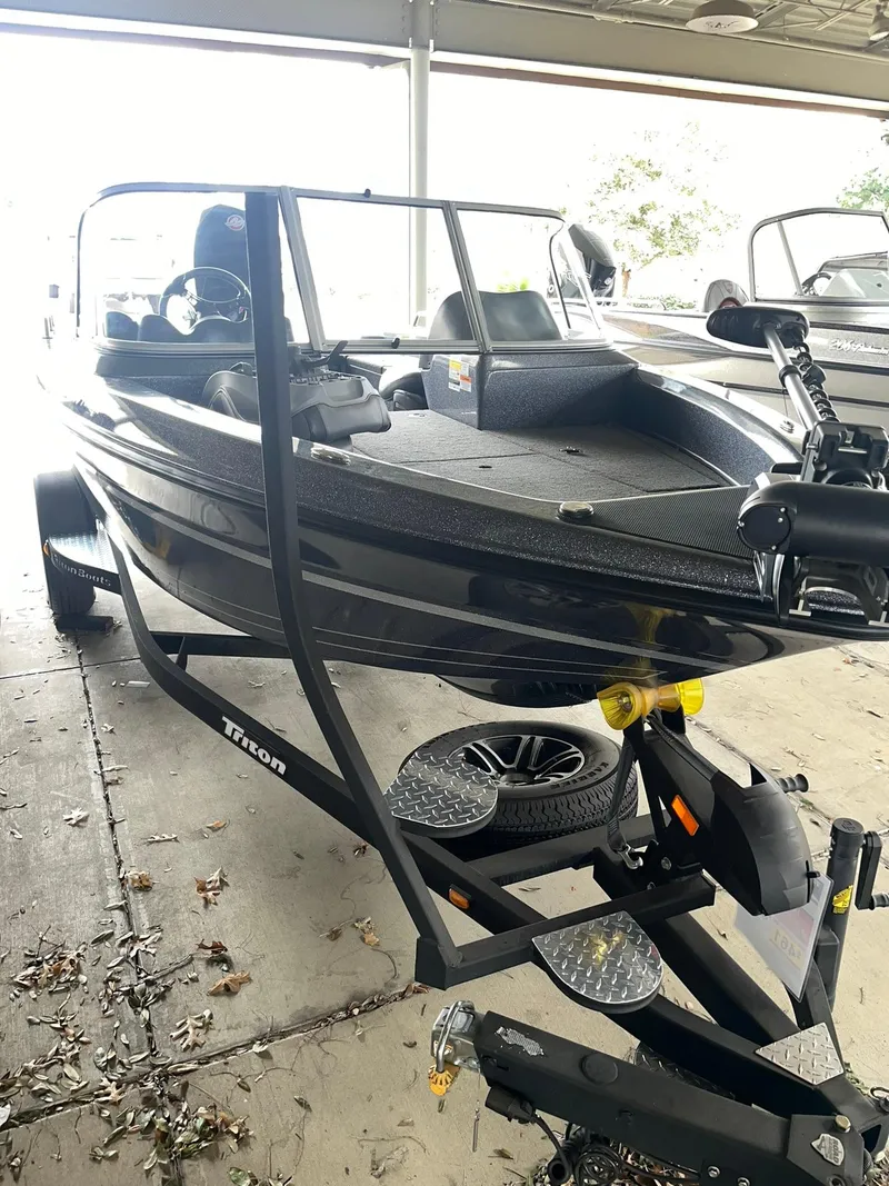 Slide: The Image of 2023 Triton 186 Fishunter boat on trailer in covered storage. - 0
