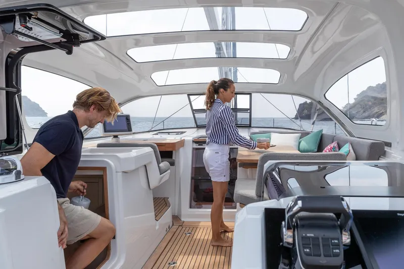 Slide: The Image of 2024 Jeanneau 55 yacht interior with people, featuring modern design and spacious seating area. - 11