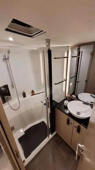Slide: The Image of 2024 Jeanneau 55 yacht bathroom with modern shower and dual sinks. - 13