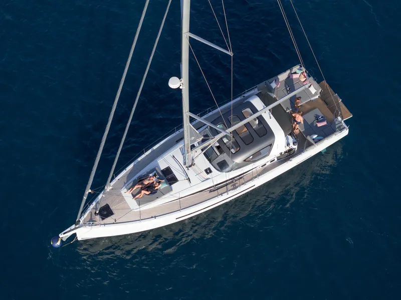 Slide: The Image of 2024 Jeanneau 55 yacht sailing on clear blue water, aerial view. - 3