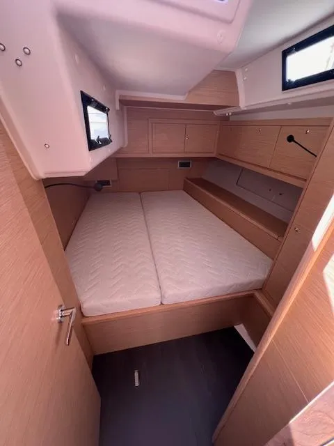 Slide: The Image of 2024 Dufour 470 yacht cabin with double bed and wooden interior. - 12