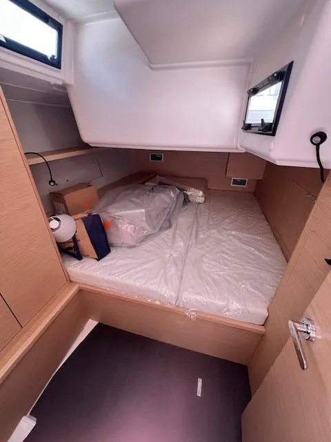 Slide: The Image of 2024 Dufour 470 yacht cabin interior with bed and storage space. - 14