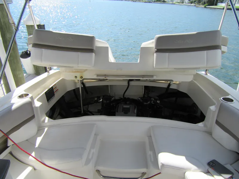 Slide: The Image of 2011 Sea Ray 250 SLX boat engine compartment with open seating, docked by the water. - 12