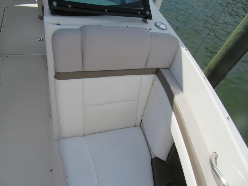Slide: The Image of 2011 Sea Ray 250 SLX boat interior with cushioned seating by the water. - 17