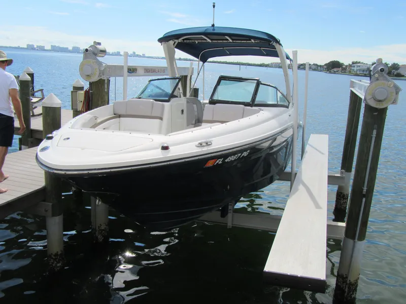 Slide: The Image of 2011 Sea Ray 250 SLX boat docked on a lift by the water. - 2