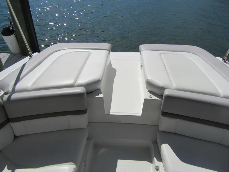 Slide: The Image of 2011 Sea Ray 250 SLX boat interior with cushioned seating by the water. - 36