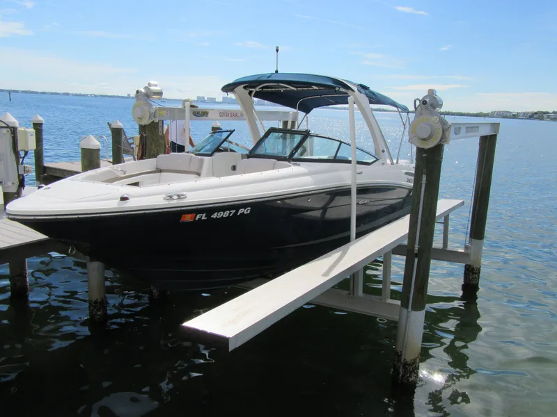 Slide: The Image of 2011 Sea Ray 250 SLX boat docked on a lift by the water. - 4