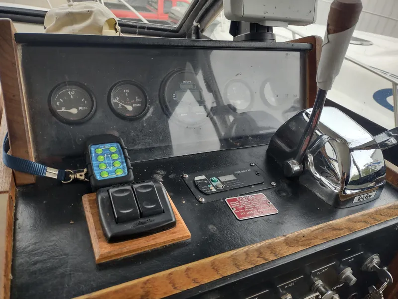 Slide: The Image of 1976 Trojan 260 Hardtop Express boat dashboard with gauges and controls. - 13