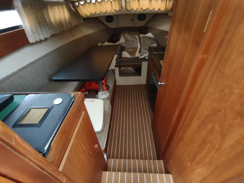 Slide: The Image of 1976 Trojan 260 Hardtop Express cabin interior with wood paneling and seating area. - 16