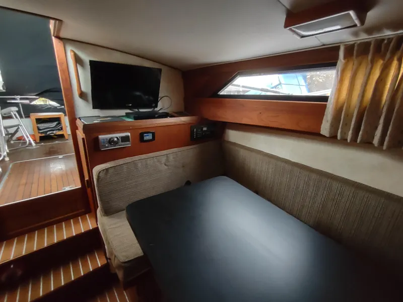 Slide: The Image of 1976 Trojan 260 Hardtop Express cabin interior with seating, table, and TV. - 19
