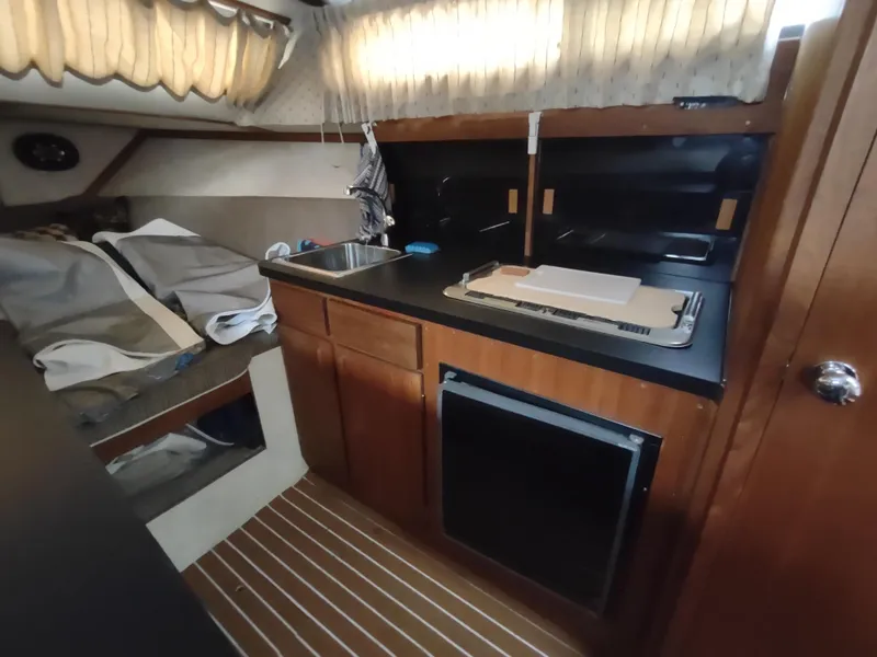 Slide: The Image of 1976 Trojan 260 Hardtop Express boat interior with kitchenette and seating area. - 20