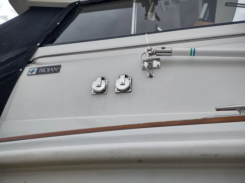 Slide: The Image of 1976 Trojan 260 Hardtop Express boat exterior with logo and hardware details. - 25