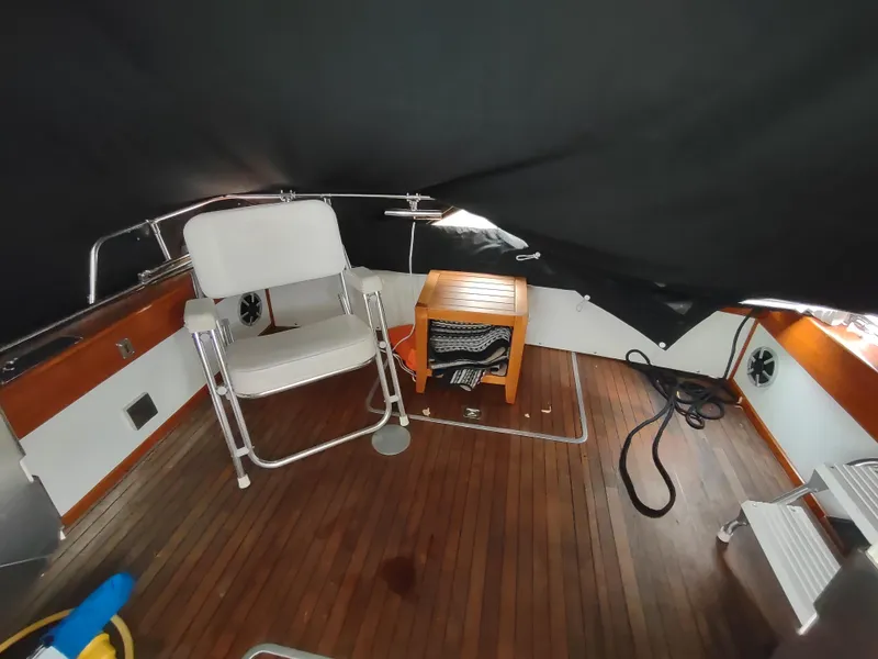 Slide: The Image of 1976 Trojan 260 Hardtop Express boat interior with wooden flooring and seating. - 6