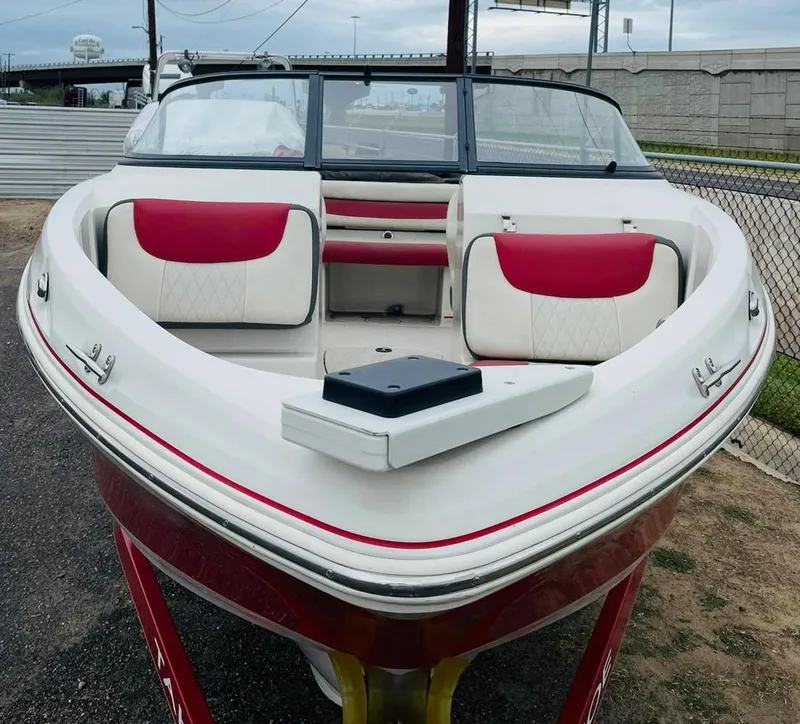 Slide: The Image of 2016 Tahoe 500 TF boat with red and white interior, docked on a trailer. - 1