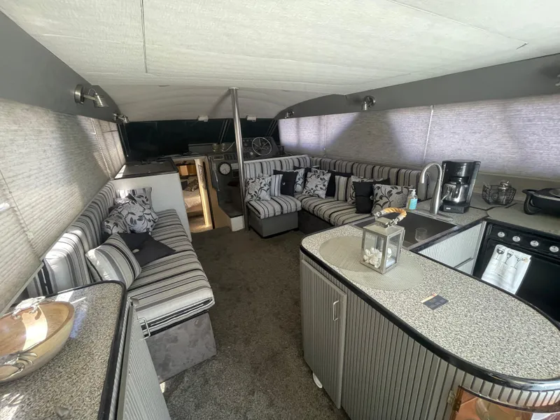 Slide: The Image of Luxurious interior of a 1986 Sea Hawk Sedan boat with striped seating and modern amenities. - 10