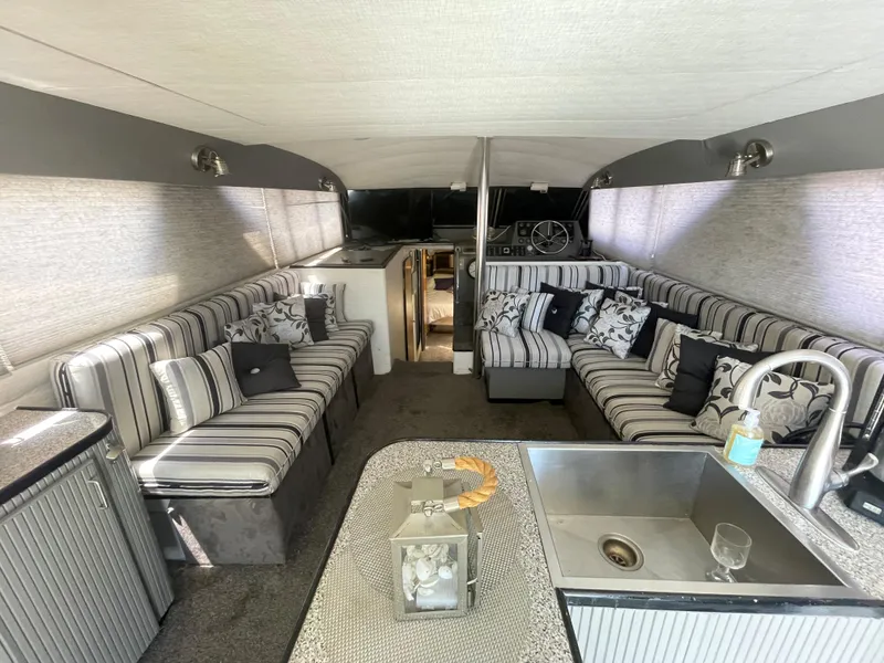 Slide: The Image of Interior of a 1986 Sea Hawk Sedan boat with striped seating and modern amenities. - 11