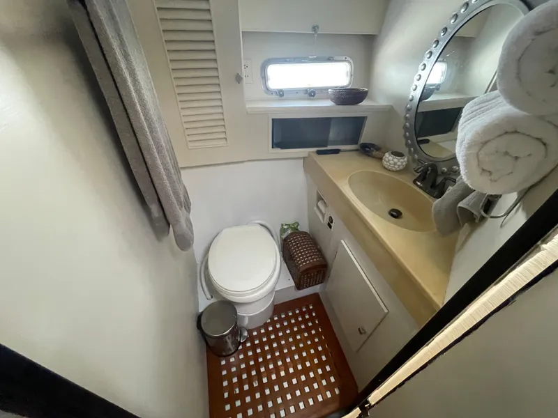 Slide: The Image of Compact bathroom in 1986 Sea Hawk Sedan boat with sink, toilet, and porthole window. - 15