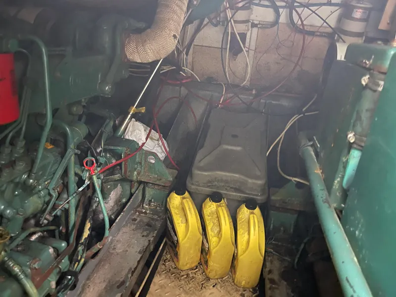 Slide: The Image of Engine room of a 1986 Sea Hawk Sedan with yellow oil containers. - 29