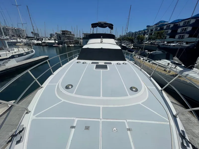 Slide: The Image of 1986 Sea Hawk Sedan yacht docked in a marina, showcasing sleek design and spacious deck. - 3