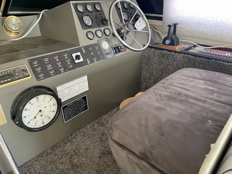 Slide: The Image of 1986 Sea Hawk Sedan boat interior with steering wheel, control panel, and plush seating. - 32