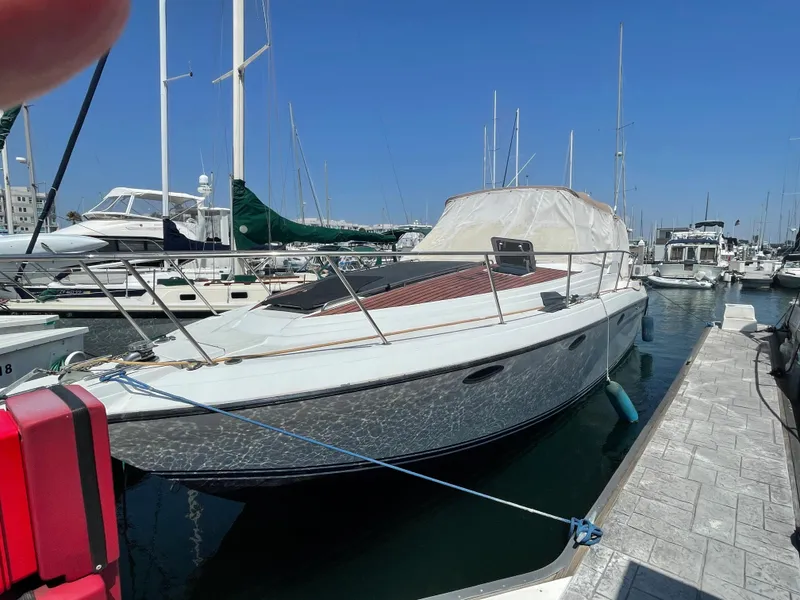 Slide: The Image of 1986 Sea Hawk Sedan boat docked at a marina under clear blue skies. - 37