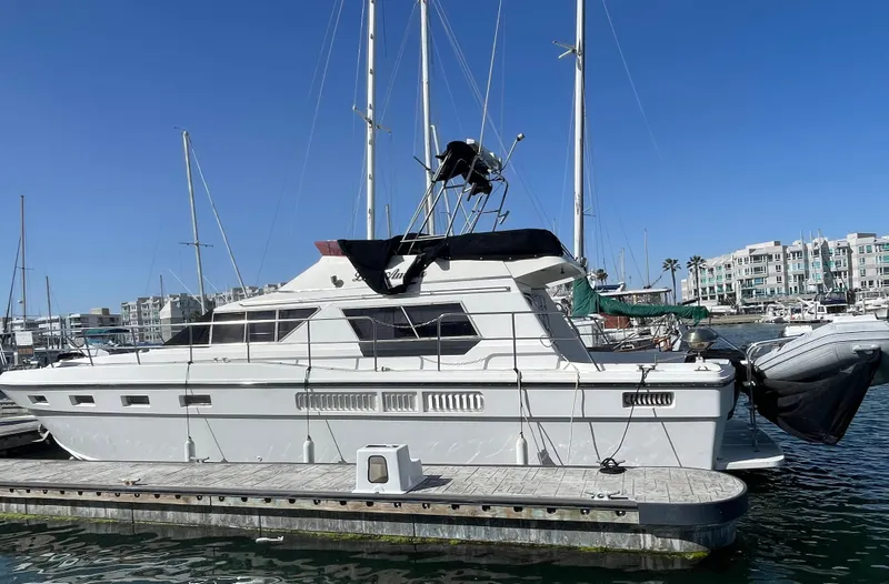 Slide: The Image of 1986 Sea Hawk Sedan boat docked at marina, clear blue sky background. - 40