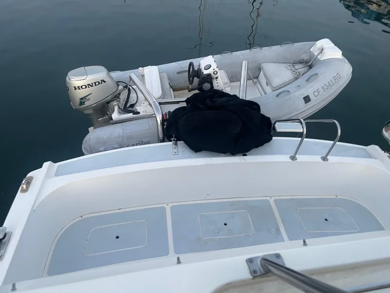 Slide: The Image of A 1986 Sea Hawk Sedan with a Honda outboard motor and inflatable boat on calm water. - 45