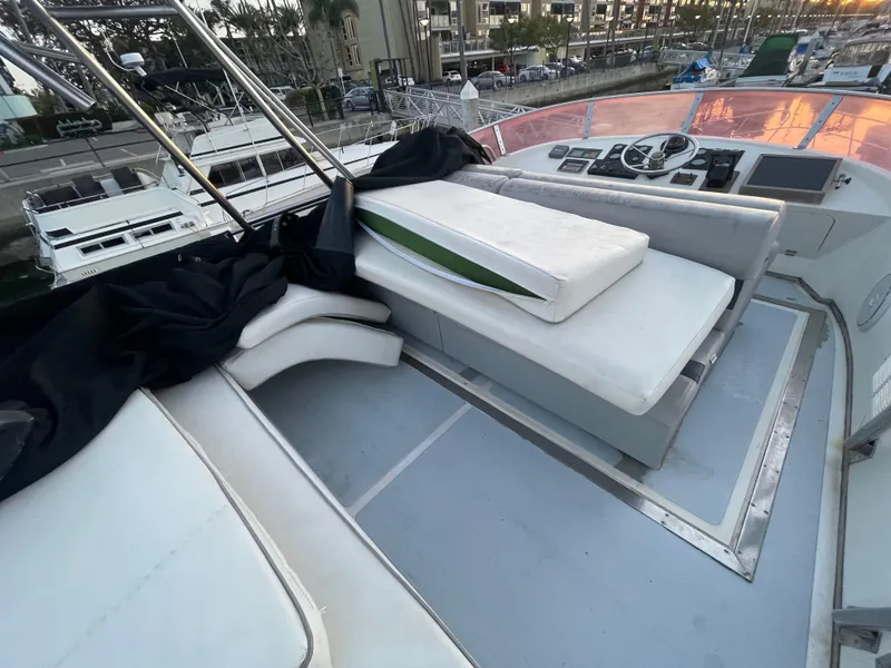 Slide: The Image of 1986 Sea Hawk Sedan boat interior with white seating and control panel, docked at marina. - 49