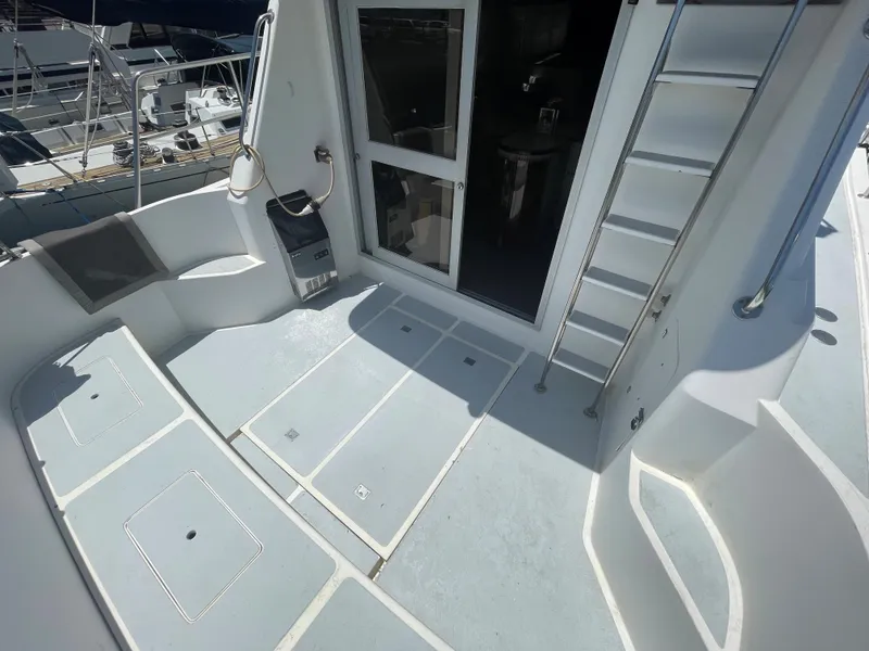 Slide: The Image of 1986 Sea Hawk Sedan boat deck with seating, ladder, and open cabin door. - 8