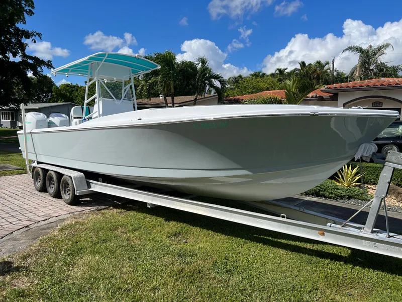 Slide: The Image of 1987 Intrepid 300 Center Console boat on a trailer in a residential area. - 15