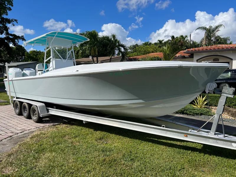 Slide: The Image of 1987 Intrepid 300 Center Console boat on a trailer in a residential area. - 16