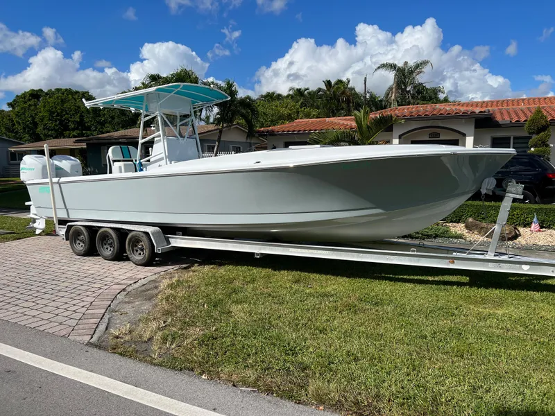 Slide: The Image of 1987 Intrepid 300 Center Console boat on a trailer in a residential area. - 18
