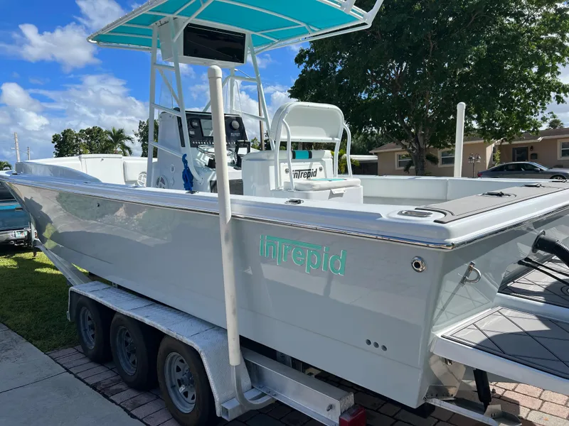 Slide: The Image of 1987 Intrepid 300 Center Console boat on a trailer, parked outdoors. - 4